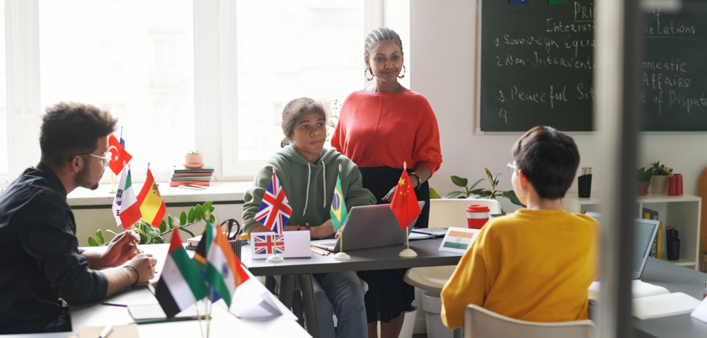 teacher and students in a classroom with various country flags