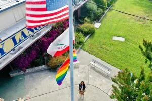 woman raising flag on school campus