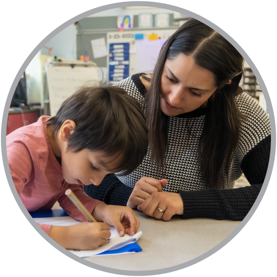 teacher helping student with writing task