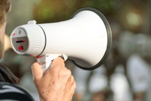 woman speaking into loudspeaker