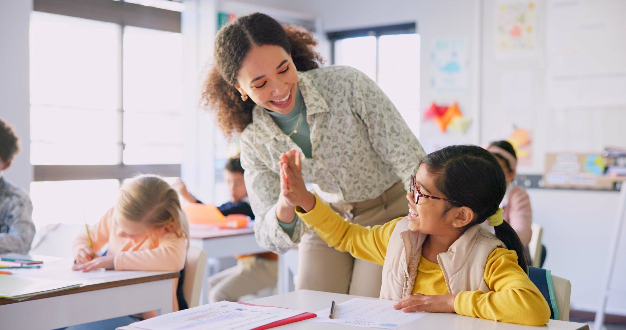 Teacher high fiving student in classroom