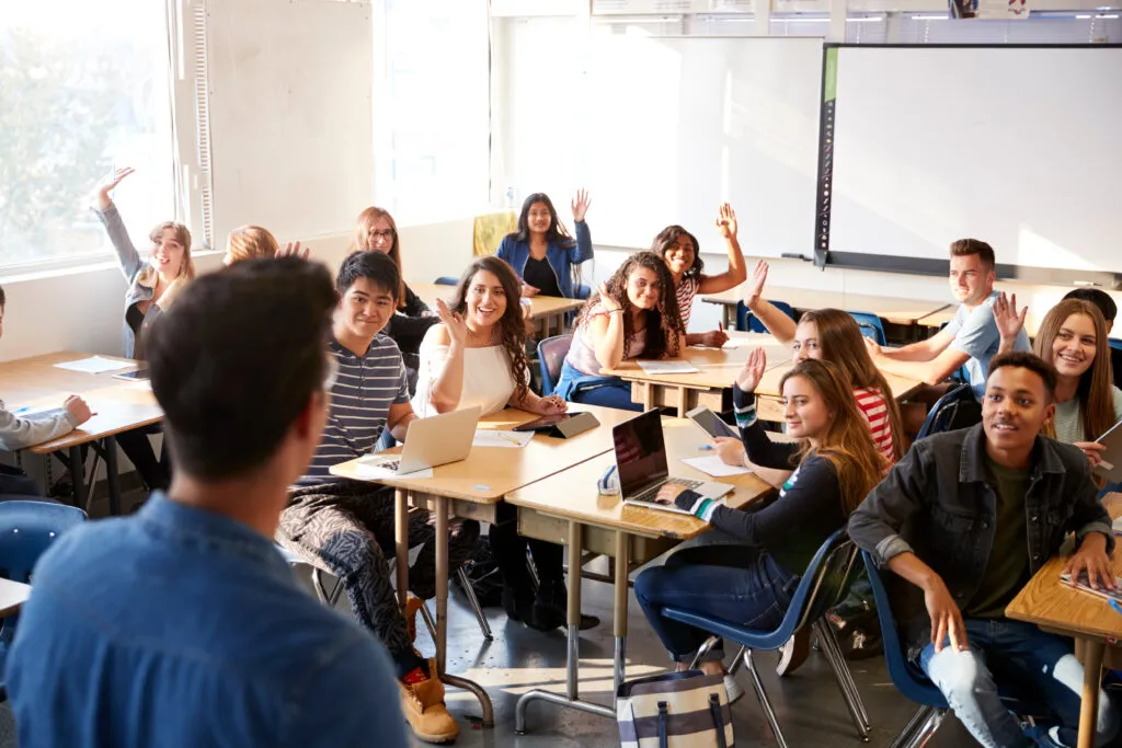 Excited classroom of students looking at teacher