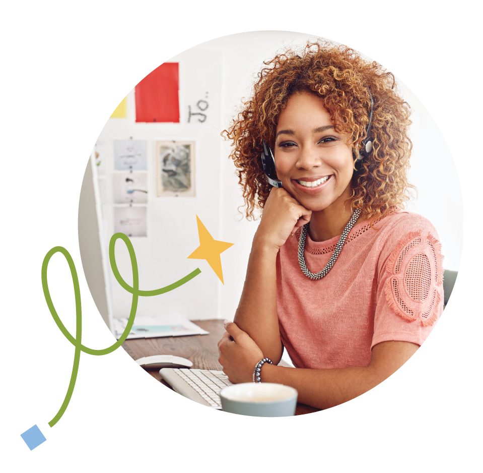 smiling customer support agent sitting in front of computer screen