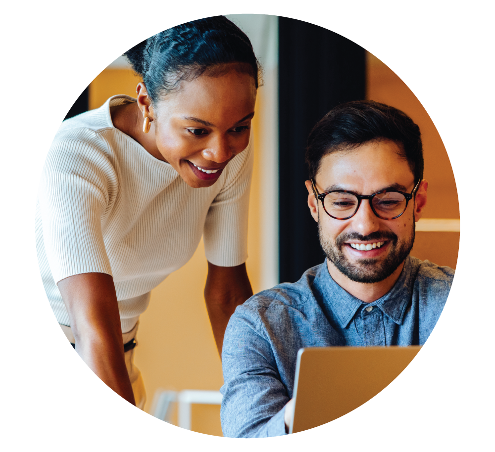 smiling man and woman looking at laptop screen