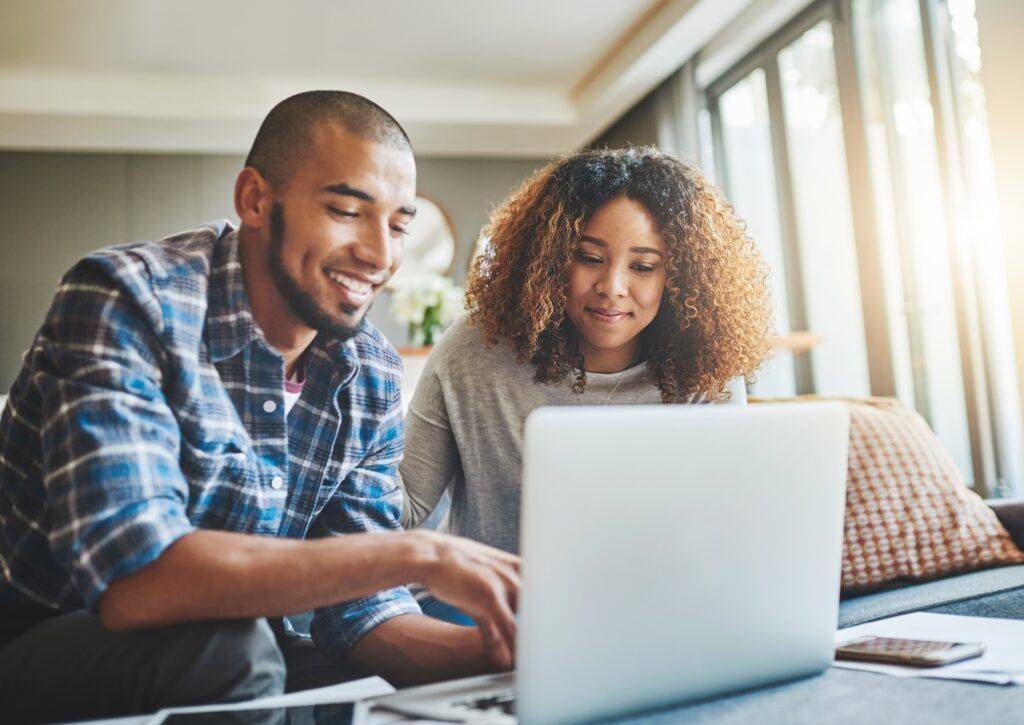 Shot of a young couple using a laptop at home
