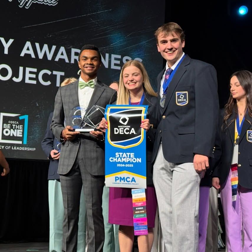 students accepting award at podium
