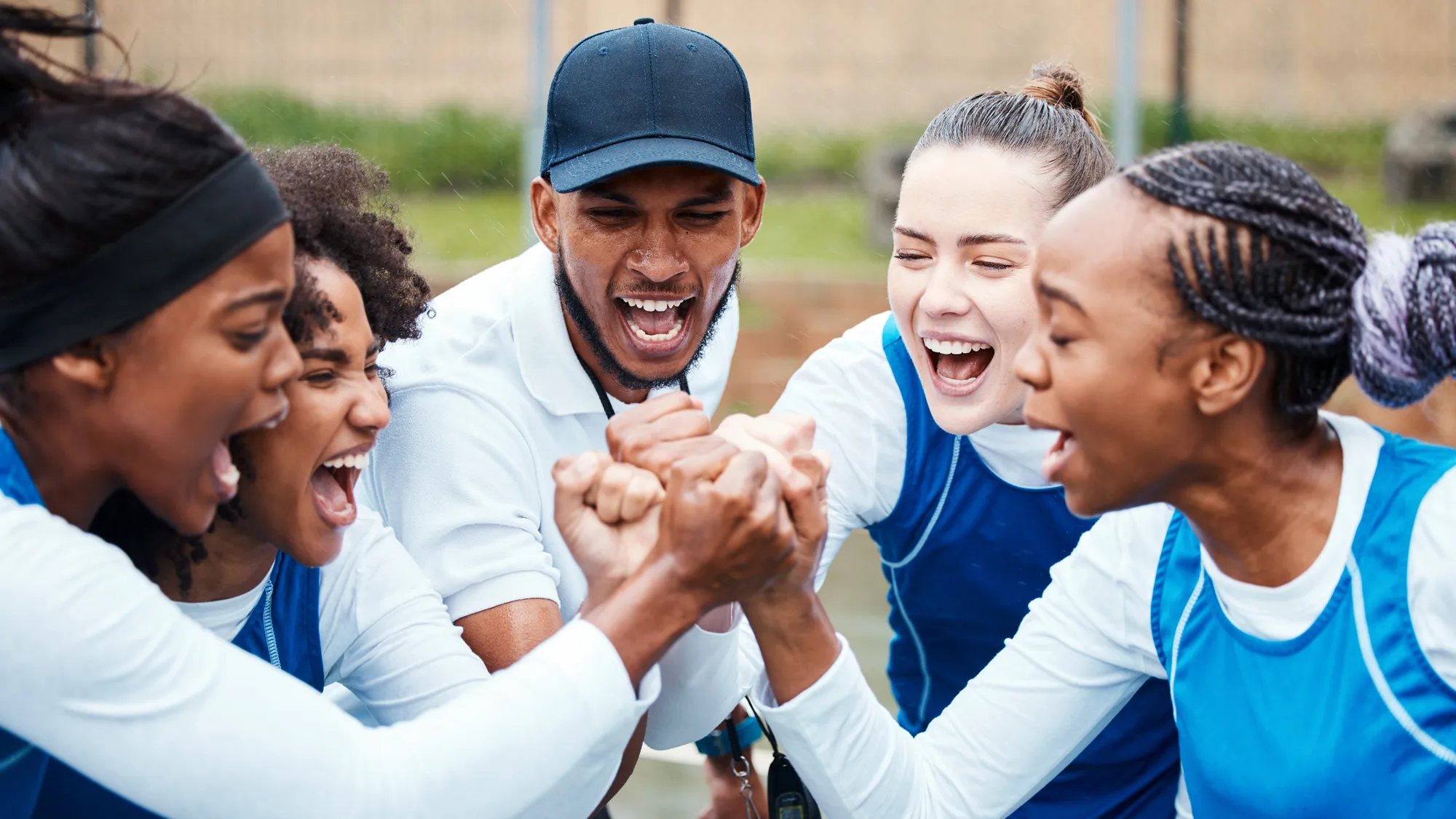 coach and student athletes engaging in pre-game cheer
