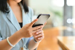 Close up woman in the office using a smartphone