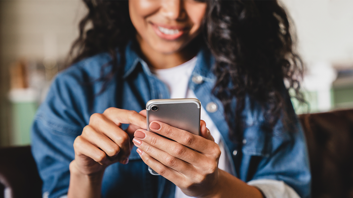 smiling woman tapping on mobile device