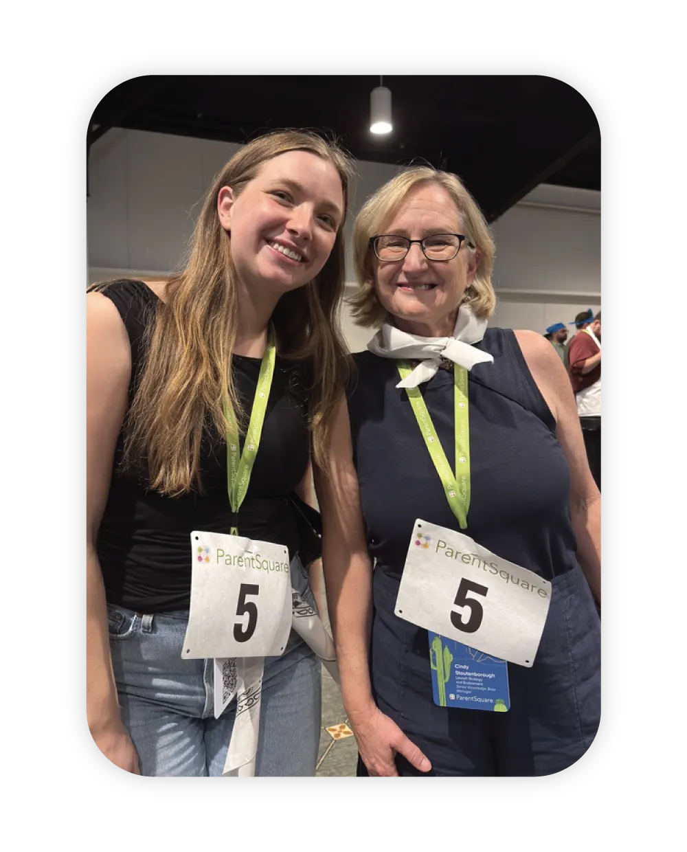 pair of smiling women wearing ParentSquare lanyards