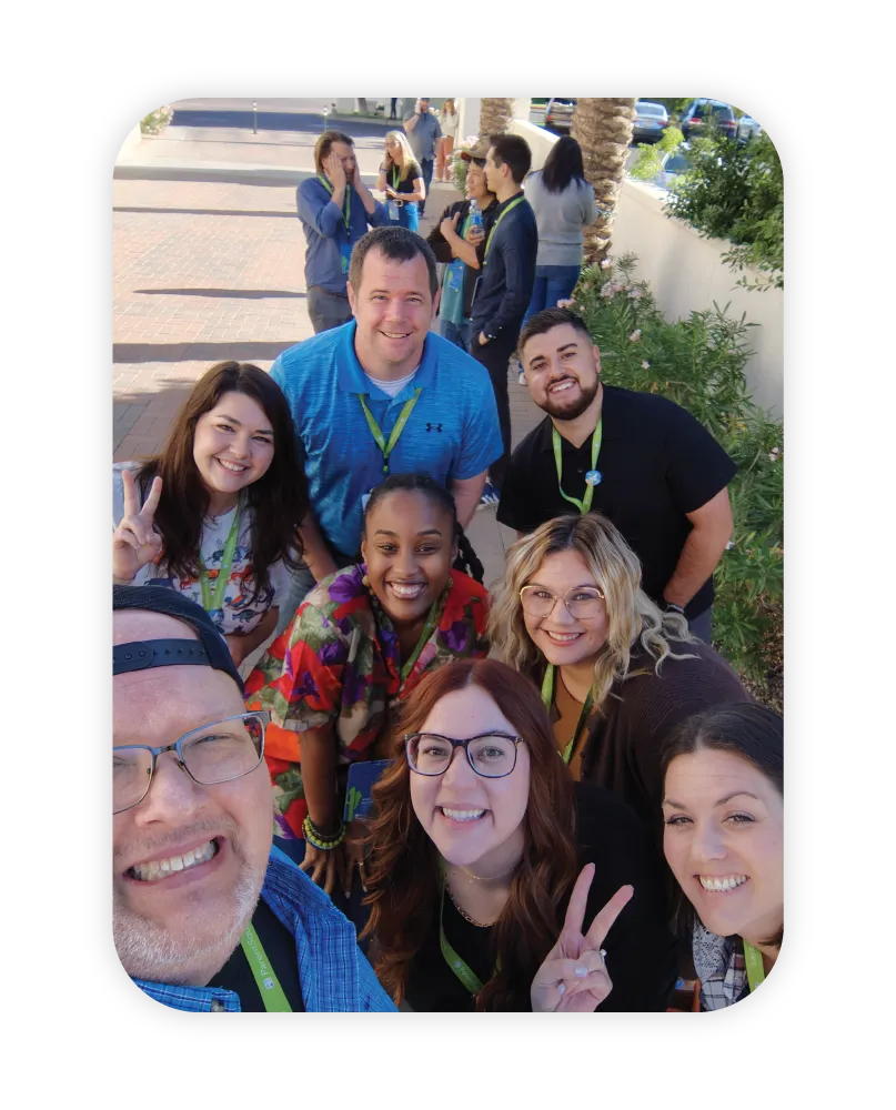 group of diverse employees outside posting for selfie