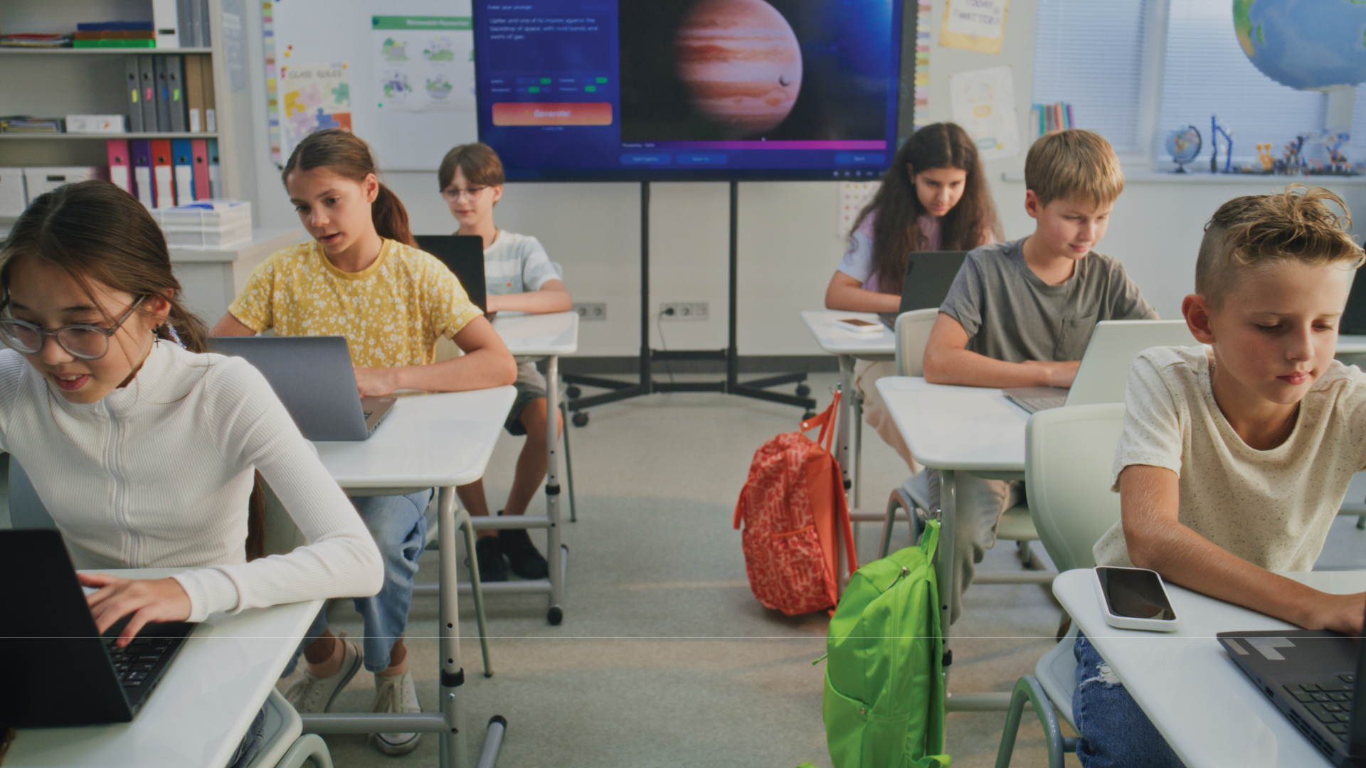 students working on laptops in classroom