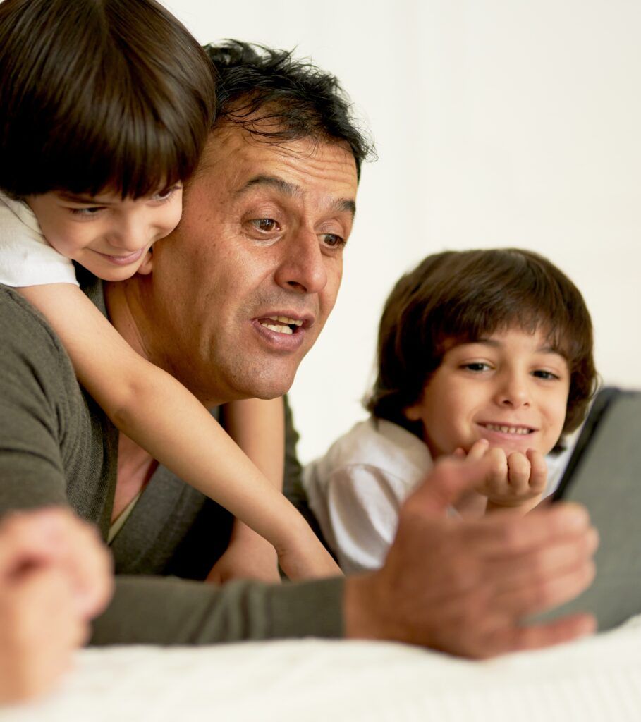 father and sons looking at digital tablet
