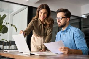 two office workers looking at laptop