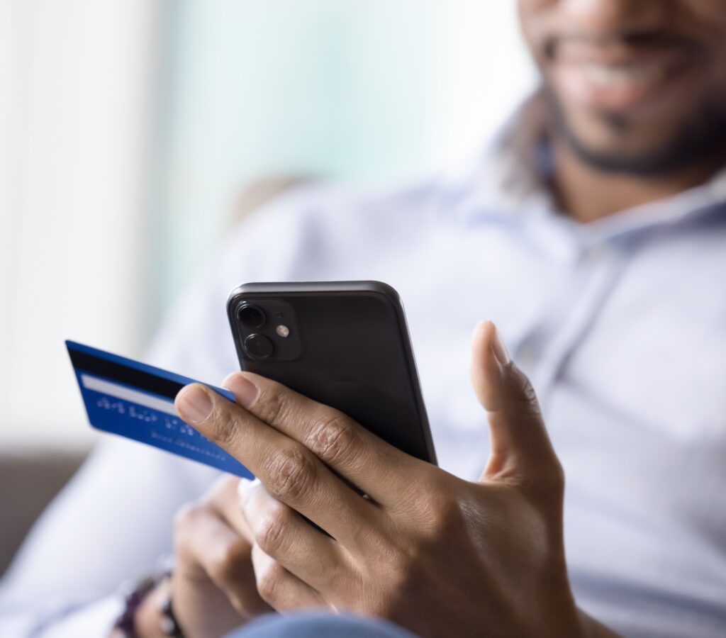 close-up of man's hand making a purchase on phone