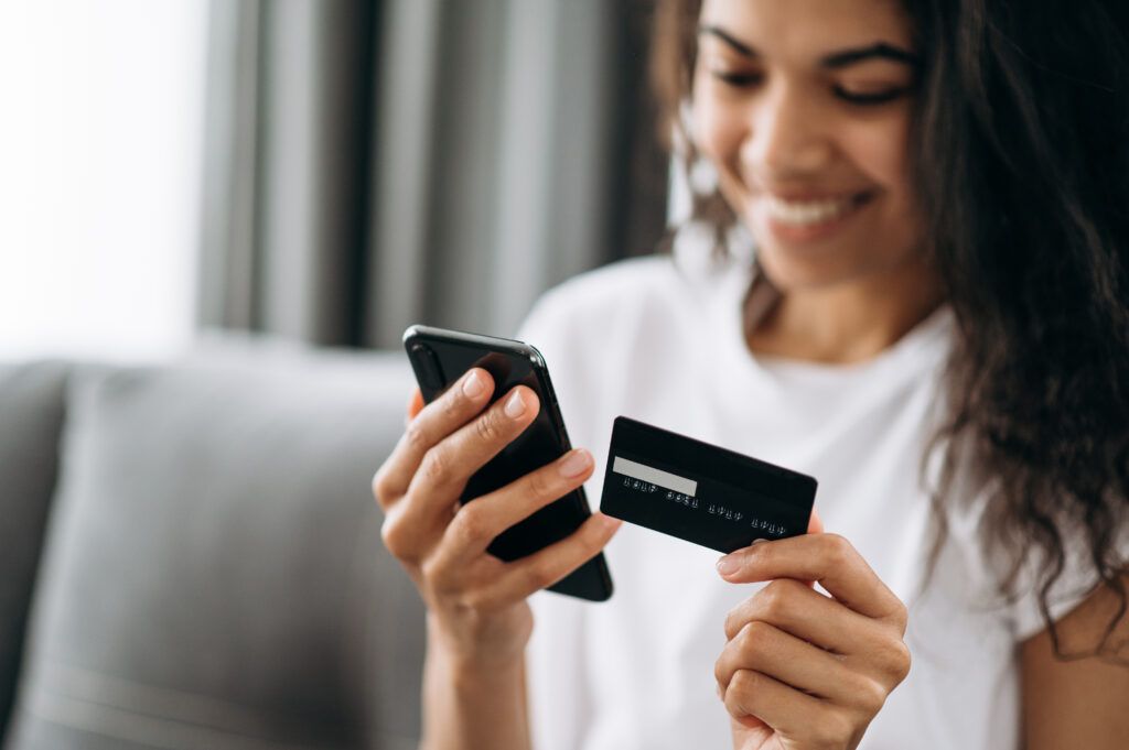 Close-up of woman paying on phone with credit card