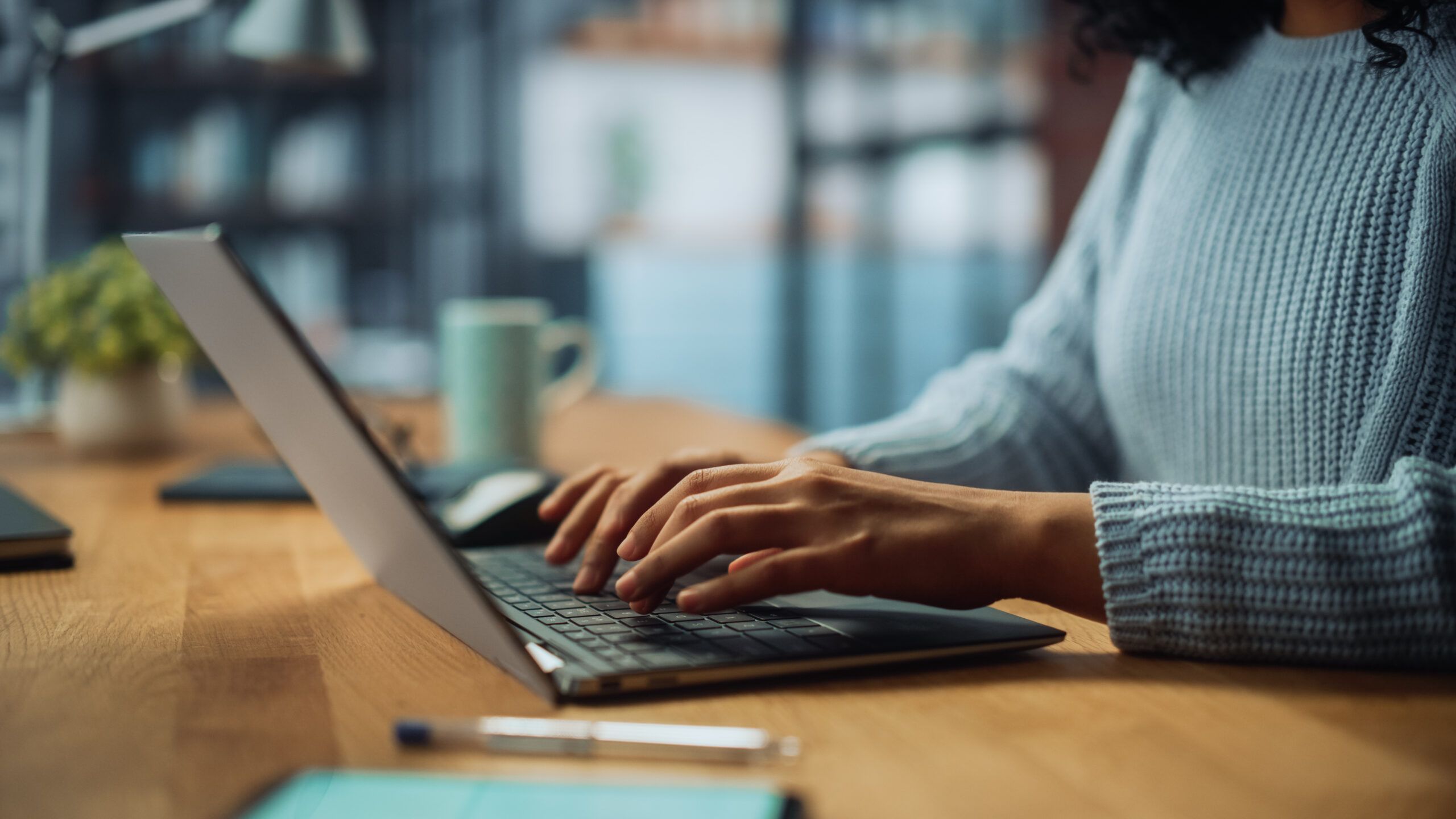 close-up of woman's hands typing on laptop