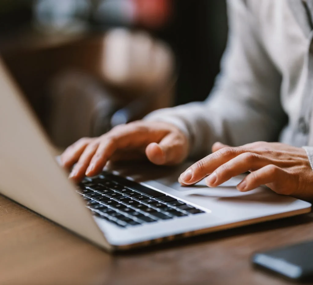 close-up of man's hands typing on keyboard