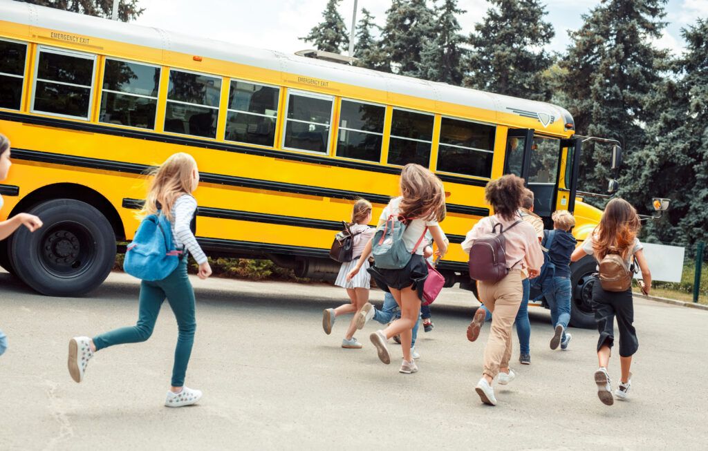 Group of children classmates runing to school bus back view