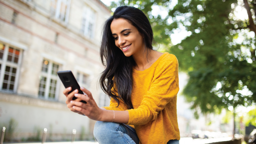 woman looking at phone outside school