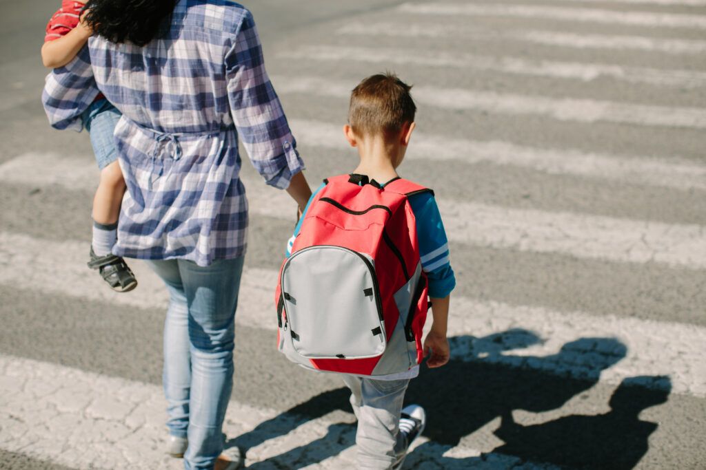Mother and her children about to cross road on way to school
